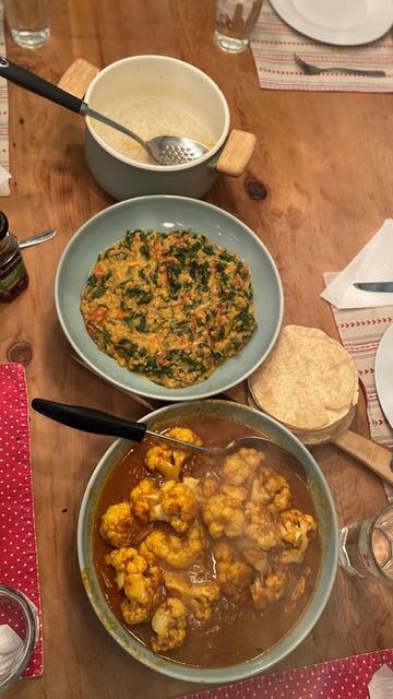 Photo of bowls of lentil dahl and curried cauliflower on a table