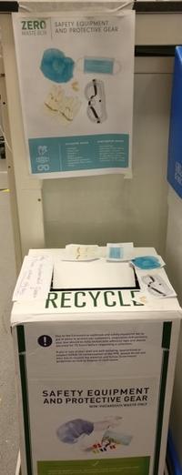 Photo of a recycling box with posters indicating that it is suitable for safety equipment and protective gear such as gloves, goggles and face masks.